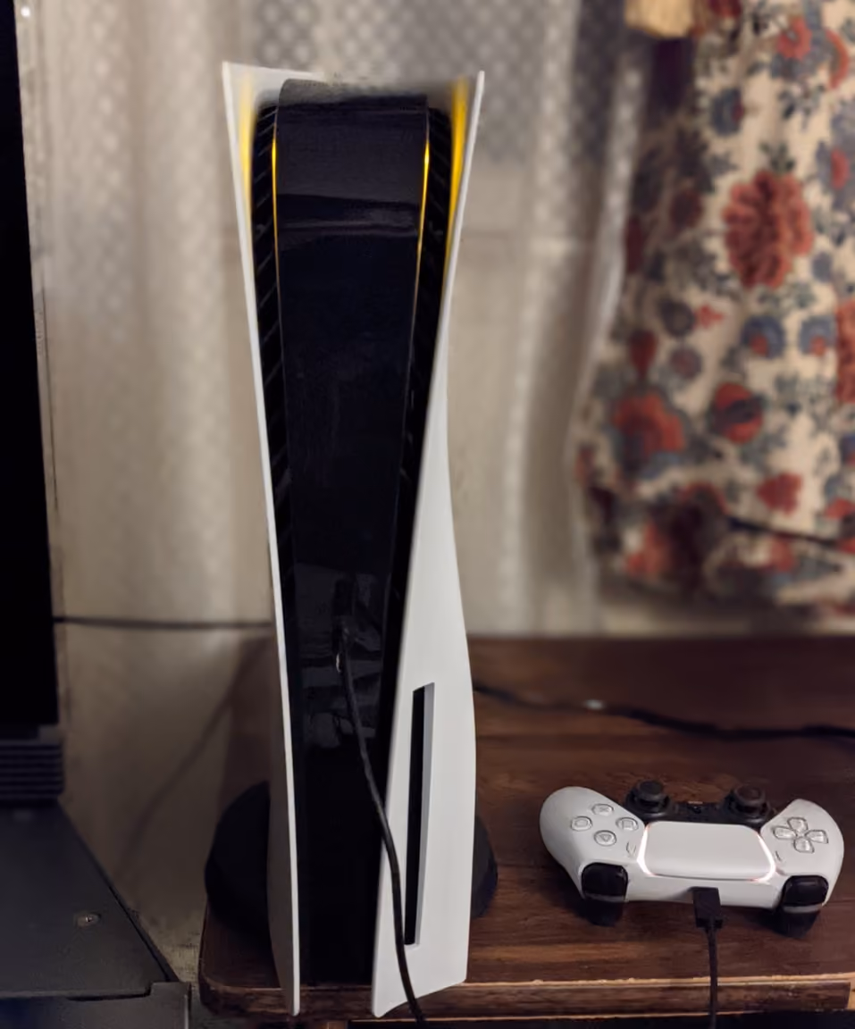 縦置きされたPlayStation 5本体と充電中のDualSenseコントローラー